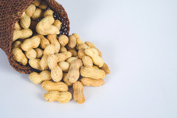 Peanut spill out of basket on background.