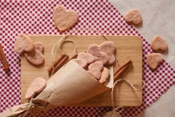 Saint Valentine's morning surprise: home made pink heart shaped biscuits served on a wooden board with cinnamon. Happy holidays!