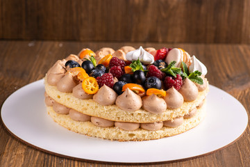 Fresh delicious homemade cake with berries on wooden table