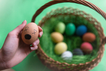Kolorowe jajka leżące w koszyczku.