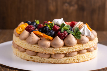 Fresh delicious homemade cake with berries on wooden table