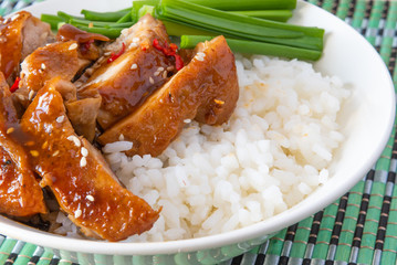 Bowl of rice with teriyaki chicken close up. Asian cuisine - Japanese, Chinese, Korean.