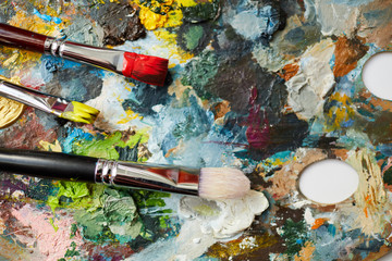 Fototapeta premium Macro close up of paintbrushes on artists palette, oil painting background