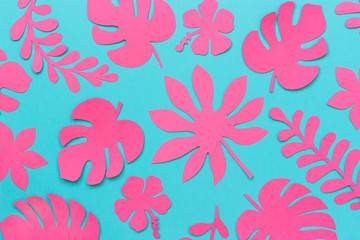 Tropical leaves pattern. Trendy pink tropical leaves of paper on blue background. Flat lay, top-down composition, creative paper art