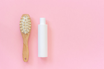 Natural eco brush and white bottle of cream for massage, peeling and body care. Concept of beautiful, healthy body and fight against cellulite. Template Copy space Top view