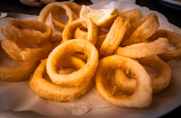Spanish tapas: Plate of Roman-style squid or fried calamari with lemon. Typical spanish food