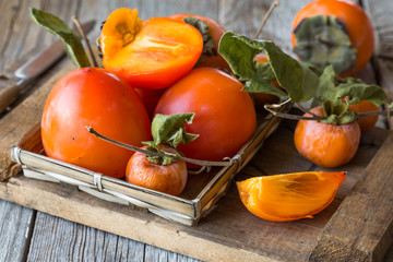 Fresh ripe persimmons on wooden background. Food background.
