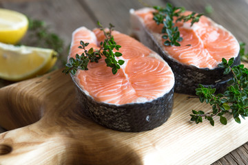 Salmon fish. Uncooked salmon fillet with ingredients for cooking - fresh lemon and spices on Wooden. Top view with copy space.