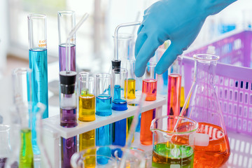 scientist with equipment and science experiments, laboratory glassware containing chemical liquid for research or analyzing a sample into test tube in laboratory