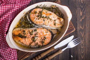 Grilled fish, grilled salmon steak with addition of lemon,  and spices on grill bowl, close-up.