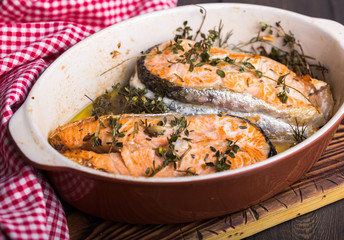 Grilled fish, grilled salmon steak with addition of lemon,  and spices on grill bowl, close-up.