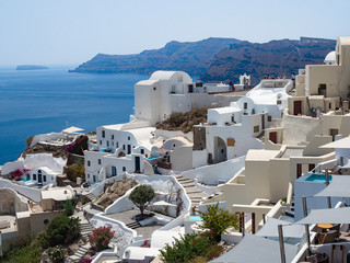 Greece, July, 2018: Oia town on Santorini island. Traditional and famous houses and churches with blue domes over the Caldera, Aegean sea