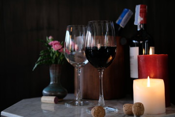 Glass of red wine and bottle of wine on wooden table