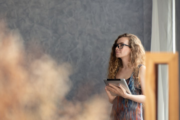 Young woman working on digital tablet computer at home