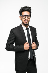 Handsome indian man in glasses standing against white background