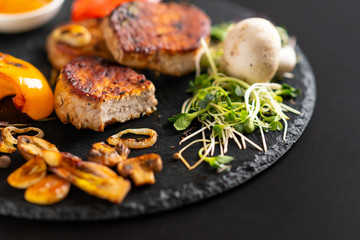 Grilled garlic cloves with sprouts and pork fillet