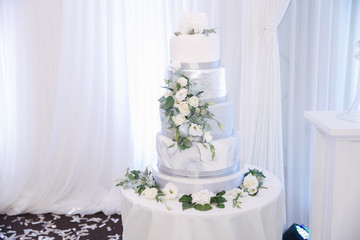 Beautiful wedding cake decorated with flowers. Silver and white color