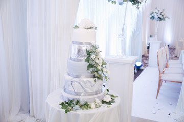 Beautiful wedding cake decorated with flowers. Silver and white color
