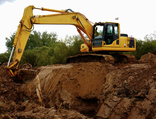 yellow excavator digs the ground