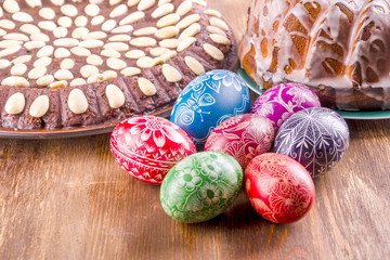 kolorowe pisanki i ciasto wielkanocne na drewnianym stole
