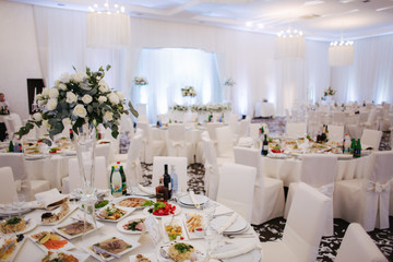 Decoration of tables in restaurant for wedding. Beautiful white decor inside