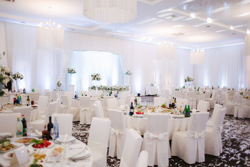 Decoration of tables in restaurant for wedding. Beautiful white decor inside