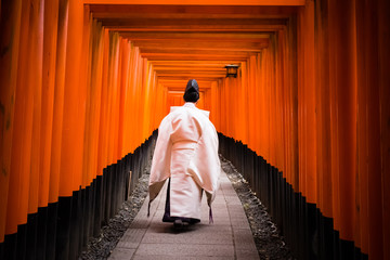 Kannushi walking alone early morning at Fushimi Inari, Kyoto, Japan