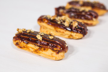 Food, bakery and desserts concept - row of eclairs on white background