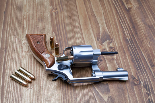 gun and bullets ready to use on  wooden table	