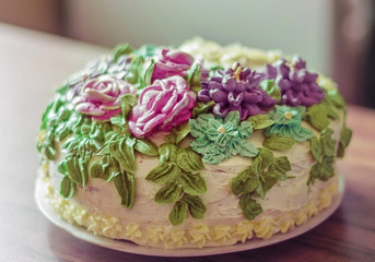 Tasty big cake decoreted with cream roses close-up