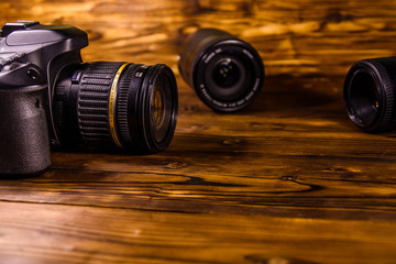 Fototapeta na wymiar Modern dslr camera and lenses on wooden table