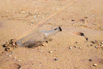 Glass bottle with rusty metal lid on sand. Garbage on the beach. Environmental pollution. Save the Planet. Ecological problem. 