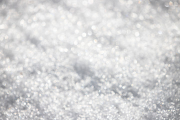 White silvery texture of defocused snow. Bright spotted bokeh.