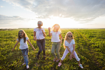Fototapeta premium Holiday, summer and fun concept - Group of people dancing in field at holi festival