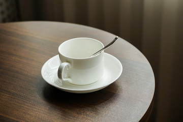white tea cup coffee cup on the table by a sofa couch in hotel room, kettle