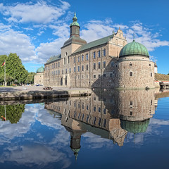 Vadstena Castle in the city of Vadstena, Sweden. The main castle building reflects in the water of...