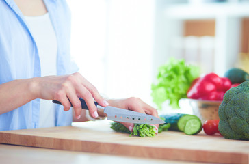 Young woman using a tablet computer to cook in her kitchen.