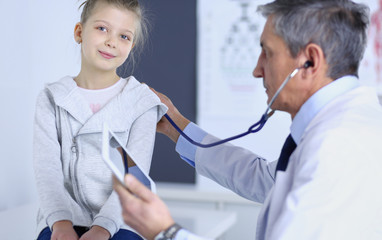 Girl and doctor with stethoscope listening to heartbeat