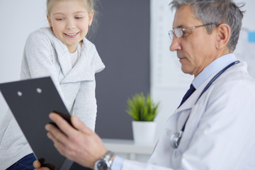 Obraz premium Portrait of a cute little girl and her doctor at hospital