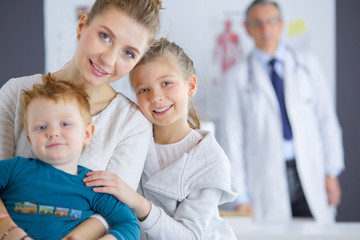 Obraz premium Little children with her mother at a doctor on consultation