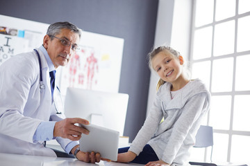 Portrait of a cute little girl and her doctor at hospital