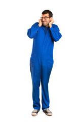 A full-length shot of a Painter man covering ears with hands. Frustrated expression on isolated...
