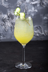 Detox lemonade with cucumber, lime, basil and spinach on a dark stone background