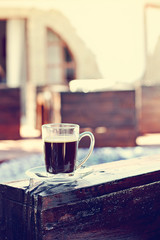 A cup of espresso and a pool in the background. Morning coffee. Summer Breakfast.
