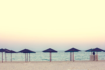 Empty beach, beach umbrellas and beautiful sunset. Romantic atmosphere.