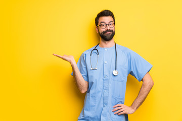 Surgeon doctor man holding copyspace imaginary on the palm to insert an ad