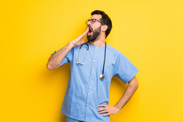 Surgeon doctor man yawning and covering wide open mouth with hand