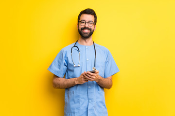 Surgeon doctor man sending a message with the mobile