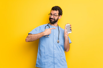 Surgeon doctor man happy and pointing the mobile