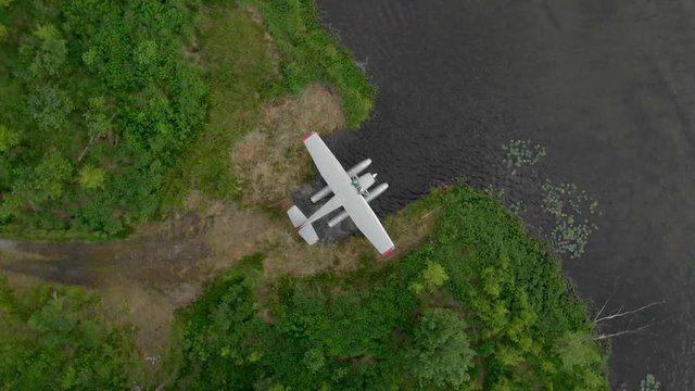 Alaska Water plane Seaplane parked on lake shore from above spin